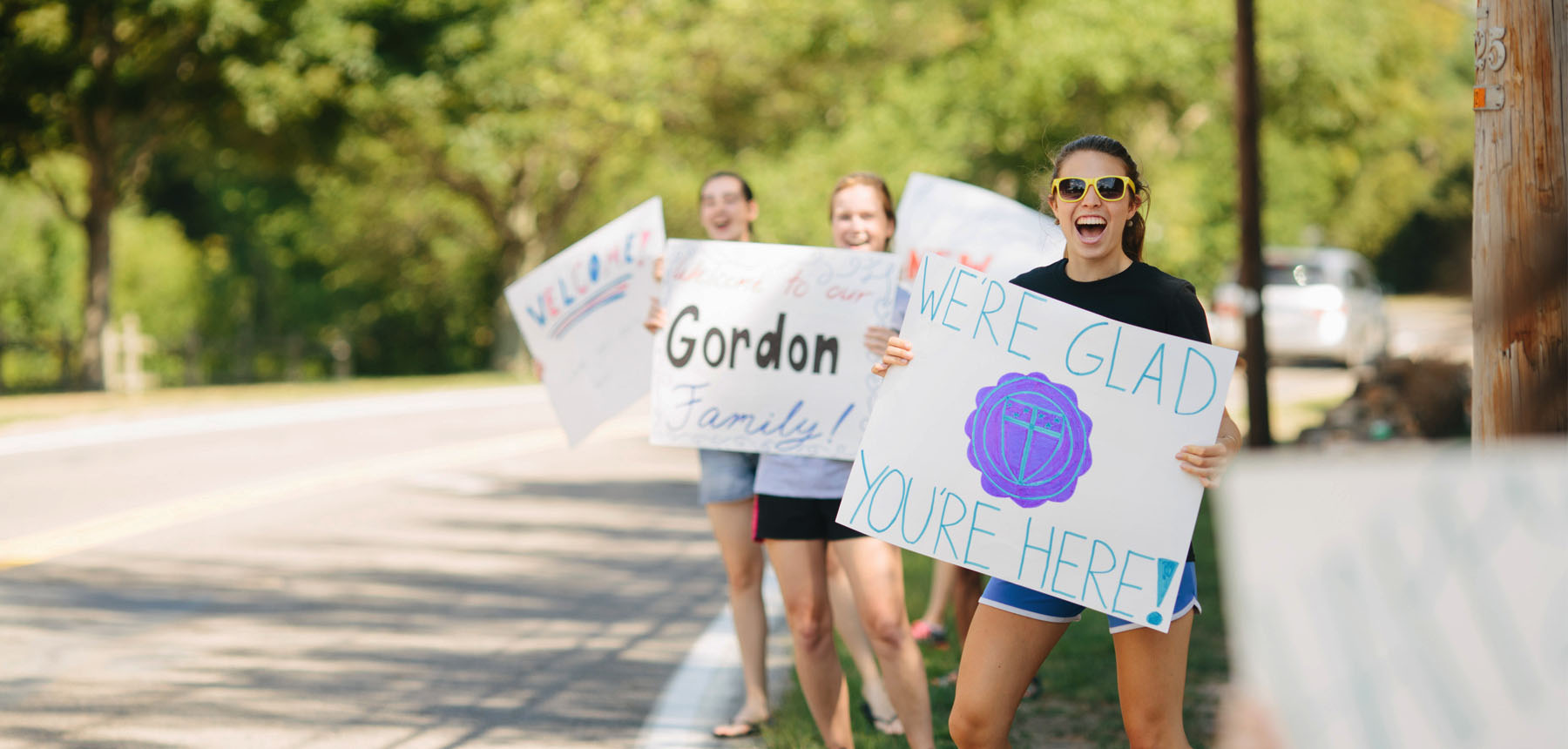 Students with signs welcoming new students