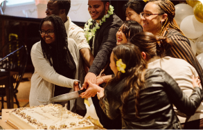 students at table cutting cake